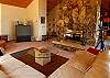 The warm and spacious living room has a large screen tv and double-faced fireplace.