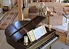 A baby grand sits off the living area near the entry.