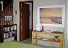 This view taken in the living area shows the entry to the bath and further left are the stairs leading up to the loft.  This view is taken over the dining table and the kitchen entry would be to the right.  Reading materials are provided for guests in bookshelves next to the stairs.