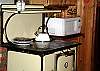 Across from the kitchen range sit an antique wood stove and microwave for guest convenience.