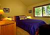 The third guest bedroom offers a queen sized bed and a lovely view of the forest.