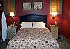 The master bedroom of the barn offers a queen size bed surrounded by exquisite antiques and art.