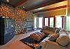 cozy den on the lower level offers a rock-faced wall and large screen TV.
