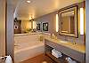 big vanity, big mirrors, big tub! A separate tile shower is behing the wall