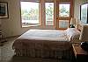 Almost every room enjoys a panoramic water view.  The hot tub is located just off this guest bedroom with a queen bed.