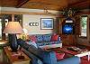 The cheeful great room of this waterfront home. There's a wood burning stove, fold out sleeper sofa, and two twin size day beds in this room also.