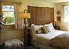 The master bedroom has a queen sized bed, a small office area, and a beautiful view of the garden and water.