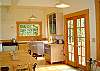 With French doors and lots of windows the kitchen of this home will be a favorite gathering place for visitors to this home.  French doors open to a grassy yard beyond.