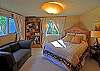 The second second bedroom offers a comfy queen bed &amp; views across the grassy yard to the water.