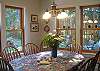 Enjoy your meals at this sunny table with plenty of chairs.