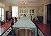 The diningroom features a massive dining table, hardwood floors and high ceilings.