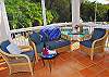 Adjacent to the kitchen, a screened in patio area provides a quiet conversation area and shade from the sunny pool deck below.