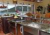 Stainless steel appliances, granite countertops, overhead scones and a tiled backsplash add to the upscale feel of this new kitchen.