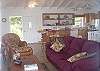The light and airy great room features comfortable furniture in rich colors.