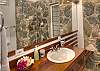 The bathrooms on the main level have spacious walk-in showers, wall-to-wall mirrors, custom vanities and built-in wooden benches. The Caribbean stonework motifs achieved have stood the test of time while maintaining the functionality and aesthetics of the design.