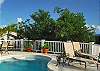 In the teardrop shaped swimming pool, stylish built-in circular shelves add visual interest and a bit of fun. Unicorn's guest cottage is nestled just beyond this pool deck.