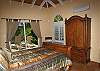 Each bedroom has a sleigh bed facing the armoire and TV.