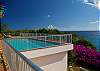 This pristine waterfront villa boasts expansive sea views, a large centerpiece pool deck  and direct access to snorkeling via a garden path.