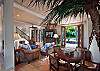 Beyond the spacious kitchen is the blue family room, a cheerful space for lounging with a large flat-screen TV and a table for cards or games.
