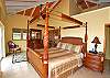 The master bedroom with high ceilings is  located on the on the upper level of Island Manor. The Caribbean style-four poster king sized has a hand carved swirling pineapple design. This large bedroom has it's own entry parlor with a lounger and television. In addition the private deck overlooks the ocean.