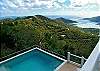 Below, the pool area on the lower deck opens out to Coral Bay and the Caribbean Sea beyond.