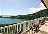 A row of rocking chairs on the expansive front deck is perfect for relaxing and enjoying the beautiful scenery.