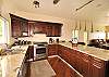 Off the Great Room's west side is the spacious, kitchen and dining area - and what a chef's delight! Well laid out and wonderfully equipped with the best of almost everything. A breakfast bar with stools slightly separates the kitchen area from dining.