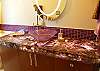 The upper master is a purple lovers fantasy with an amethyst gemstone vanity top  imported from Brazil. Lit from beneath the vanity glows to show the beauty within.