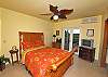 On the lower level, this queen sized sleigh bed faces the covered porch. You have direct access to the pool from this warm tropical bedroom.