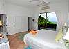 The Bliss bedroom has sliding glass doors that open onto a large deck with shimmering Coral Bay water and mountain views. It has a king bed, air conditioning and ensuite bath.