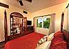 The modern mahogany four-poster king bed, faces a wide arched doorway which escorts you directly to the master bath.