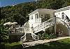 Twin curved staircases lead down to Paulette's sunny pool deck, set right above the green lawn and gardens.