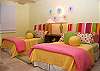 The pinks, yellows and greens of the second guest bedroom offer a whimsical side to Abrigado.  This bedroom features two double beds and a private bathroom as well as it's own flat screen TV and DVD player.