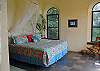 The master bedroom is surrounded on two sides by large windows designed to illuminate  the room without compromising privacy.
