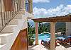 The coral tiled courtyard is capped by a massive pergola that keeps the area shady and comfortable in the tropic breezes. Up the stairway lies the Master bedroom suite.