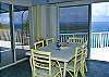 The indoor dining table comfortably seats six. Beyond sliding glass doors on two sides, the Caribbean Sea provides a serene backdrop.