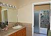 The well-lit master bathroom is very special, with a garden-style outdoor shower with native stonework walls.