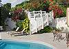 A convenient stairway leads from the pool area directly to the driveway. Halfway up, a seating area is nestled amongst the flowers.