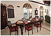 Surrounded by colors that include crème, coral, lime and caramel, guests can dine at the eight-person formal mahogany table.