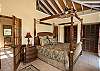 The master bedroom with its high vaulted ceilings is located on the upper level of Island Manor. The Caribbean style-four poster king sized bed has a hand carved swirling pineapple design typical of the original Estate houses.