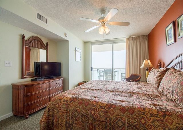 Master Bedroom with a king size bed and sliding glass door to the ocean front balcony.