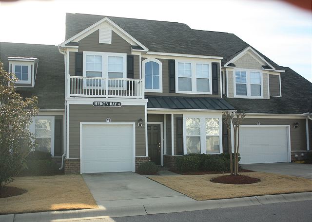 Super curb appeal from the front view of this beautiful Heron Bay townhouse