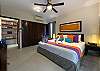 Wide view of the bright king bedroom with A/C, ceiling fan, generous closet space, and an open, uncluttered layout.