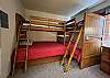 Bedroom#3 is a bunk room featuring two sets of bunk beds. The bunk bed set on the right offers two twin beds. The bunk bed set on the left offers a full bed on the bottom and a twin bed on the top.