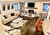 The living room is part of an open concept floor plan where guests can gather throughout the kitchen/dining/living areas.