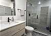 This full bathroom features a huge walk-in tile shower and is a private bathroom to the primary bedroom.