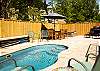 Back Patio with privacy fence, pool, hot tub, grill, and outdoor dining area!