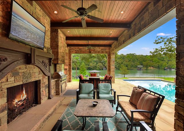 Outdoor living complete with seating, TVs, and fire place.