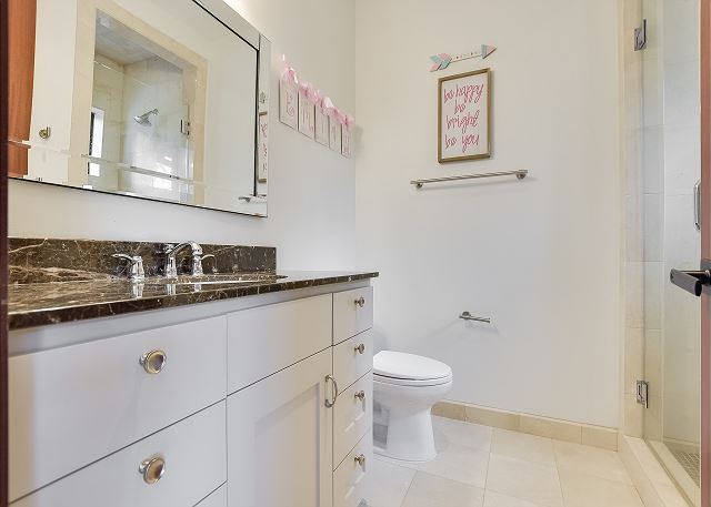 Full bathroom with marble counter tops.