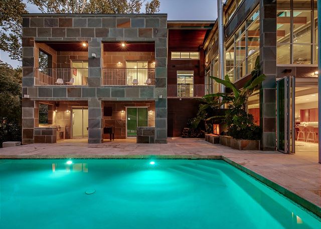 Open outdoor area with pool and outdoor kitchen facing the lake